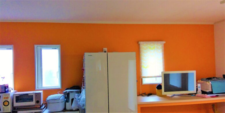 キッチン背面のオレンジ色のアクセントクロスは狙い通り。視覚的効果でしっくりくる